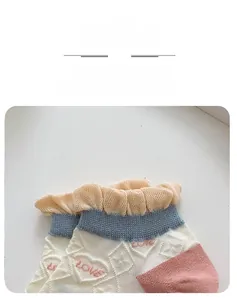 Detail of knit socks featuring sweet ruffled edges and pink LOVE heart patterns