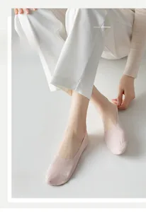 Detailed close-up of light pink ice silk no-show socks featuring a round white printed logo