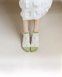Detail of floral women's ankle socks with green lace edges and daisy pattern