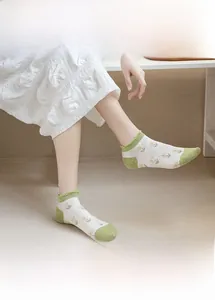 Close-up of mesh floral ankle socks featuring green flower patterns and ruffle cuffs
