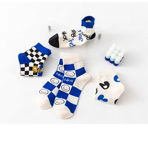 Close-up of stylish cotton mid-calf socks with blue checkered and smiley patterns