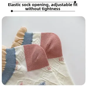 Close-up of elastic pink ruffled cuff on checkered socks with LOVE knitting detail