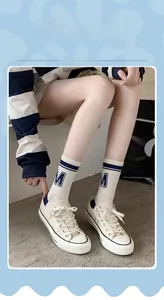 Close-up of sporty crew socks featuring blue stripes and M letter with canvas sneakers
