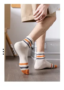 Detail of men's crew cotton socks with orange stripes and embroidered logo on the ankle