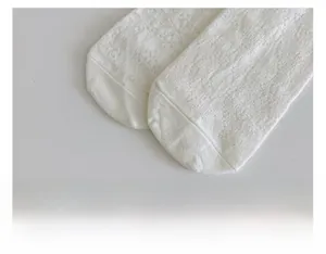 Macro detail of breathable white mesh socks showing seamless toe stitching and texture