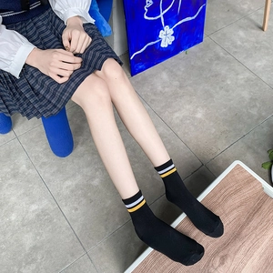 Calze nere classiche con strisce gialle e bianche e bordo a coste in stile preppy