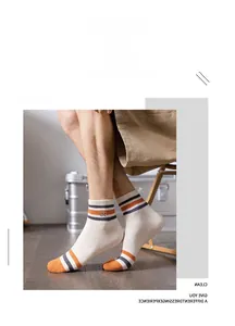 Close-up of crew cotton sports socks in beige with blue stripes and circular embroidery