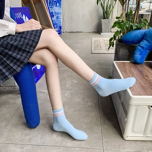 Calze di cotone a righe azzurre per donna indossate da una modella in un ambiente interno