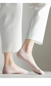 Close-up of thin nude-colored ice silk invisible socks worn with light-colored trousers