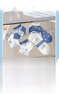 Détail de chaussettes en coton bleu et blanc avec motifs d'ours et bords ondulés