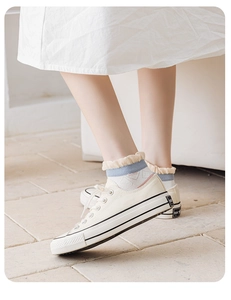 Detail of sweet ruffle cuff socks with blue stripes and LOVE embroidery worn with shoes