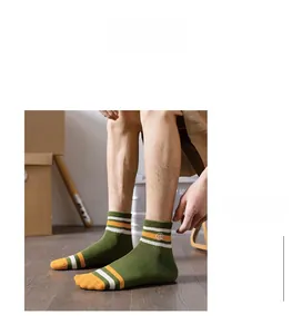 Detail of military green cotton crew socks with ribbed cuffs and yellow stripes