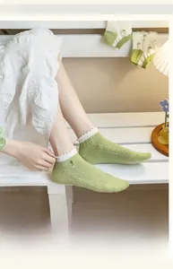 Detail of light green knit ankle socks with white ruffle trim and cactus embroidery