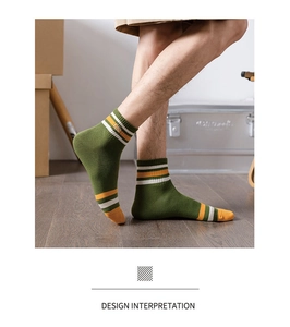 Detailed shot of retro forest green cotton socks with yellow stripes and embroidery
