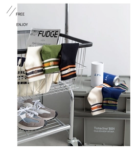Detail of cotton crew socks featuring classic triple stripes and circular embroidered logo