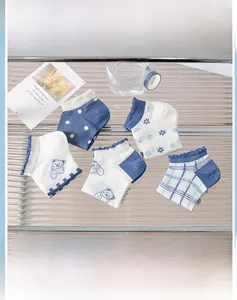 Détail de cinq paires de chaussettes en coton bleu et blanc avec motifs ours et jacquard
