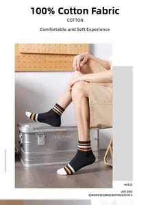 Close-up of cotton crew socks with orange stripes and embroidery on a male model