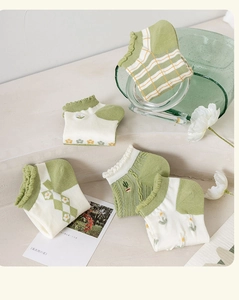 Close-up of five pairs of green and beige floral embroidery cotton low cut ankle socks