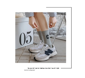 Close-up of grey ribbed cotton socks with black C letter embroidery and stylish texture