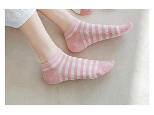 Detailed view of pink and white checkered low cut ankle socks on marble background
