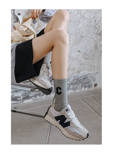 Detail of cotton crew sock with C letter embroidery paired with retro sneakers