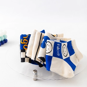 Klein blue checkerboard crew socks with smile face and slogan on an acrylic display stand