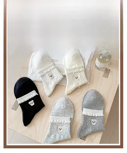 Detail of ruffled lace cuffs with bear embroidery on assorted cotton ankle socks