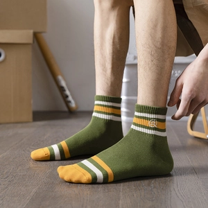 Men's retro green cotton crew socks with yellow stripes and circular embroidery detail