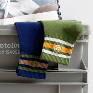 Men's striped cotton crew socks in navy and green with embroidery on industrial background