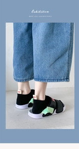 Detail of platform sports sandals with purple sole and black velcro straps worn with socks