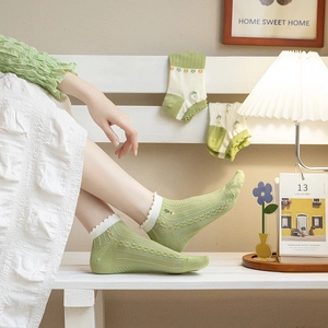Pastel green knit socks for women with white ruffled cuffs and delicate flower embroidery