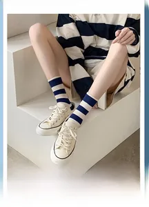 Detail of blue and white striped jacquard socks styled with white canvas sneakers