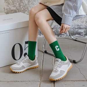 Gray casual sneakers with yellow rubber sole and green socks featuring 'C' embroidery