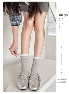 Detail of grey ribbed crew socks with white lace trim and silver Mary Jane ballet shoes