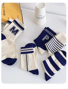 Detail view of cotton mid-calf socks with striped college style letters and props