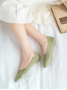 Close-up of 10 pairs light green invisible socks on feet with soft elastic knit texture