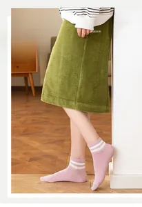 Close-up of pink low-cut sports socks with white stripes on soft wood flooring
