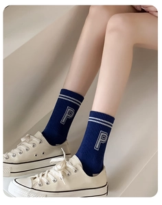 Detail of navy blue athletic mid-calf socks featuring white stripes and P letter embroidery