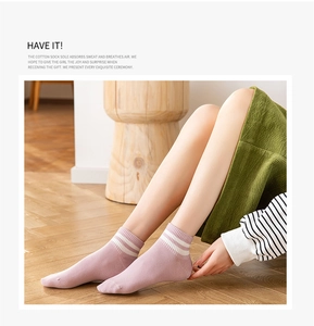 Detail of pink-purple low-cut cotton socks with white stripes on a model in a cozy setting