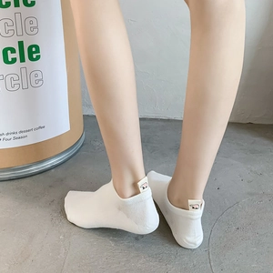 White low-cut ankle socks for women featuring a small bear logo tag on the heel