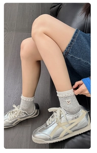Detail of light gray socks with cute brown bear embroidery and wavy ruffled cuff style