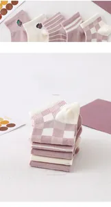 Close-up of soft purple cotton socks with stripe patterns and fruit embroidery detail