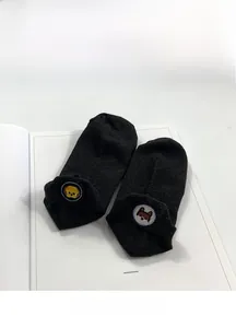 Detail of dark grey cotton boat socks with cute lion and puppy heel embroidery