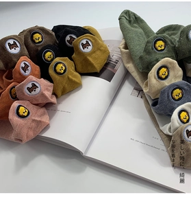 Detail of colorful ribbed cotton socks featuring cute embroidered animal characters