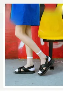 Close-up of white ultra-thin breathable plaid socks worn with black sandals