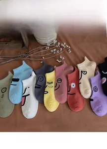 Close-up of colorful cotton ankle socks featuring assorted cartoon facial expressions