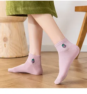 Close-up of pink low-cut cotton socks featuring a delicate purple grape embroidery detail