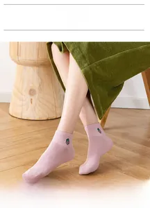 Close-up of pink cotton ankle socks with fine ribbing and purple grape embroidery detail
