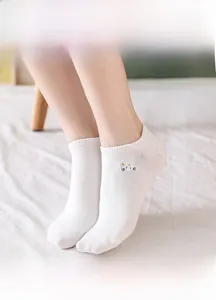Detail of white cotton low-cut sock with colorful cartoon sheep embroidery on a model