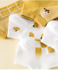 Détail de chaussettes basses en coton style coréen avec motifs jaunes et marguerites